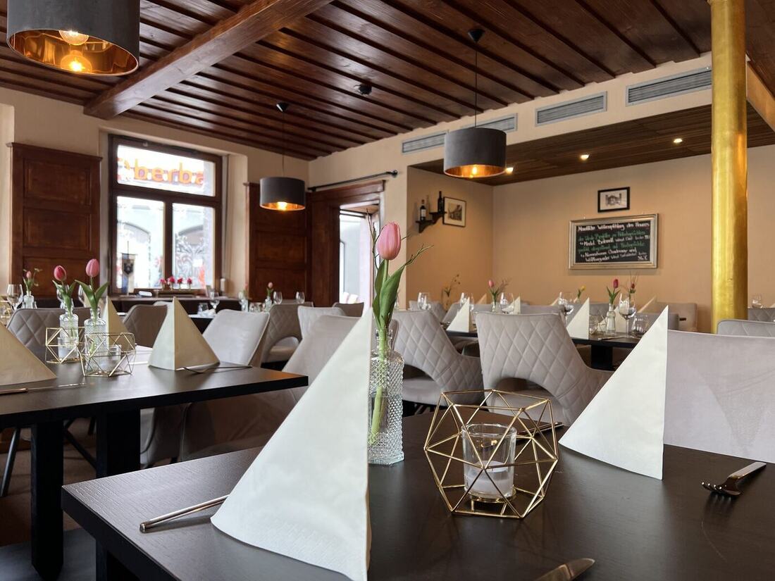 Ochsen Stube im Restaurant Ravensburg — gedeckter Tisch mit Tulpen und goldenen Lampen